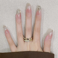 Hand with long, decorated nails and a gold ring on a textured background
