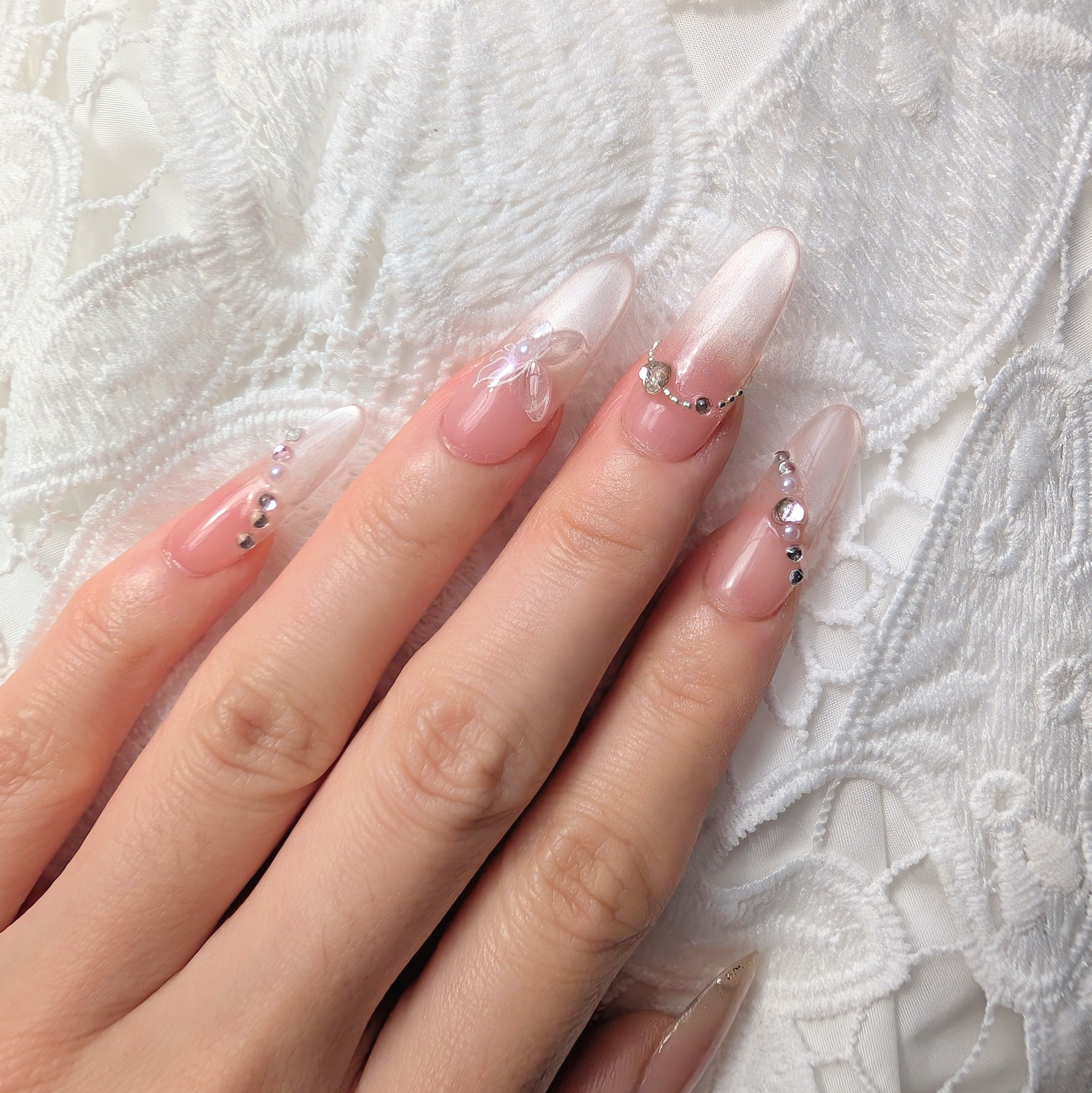 Close-up of a hand with decorative nails on a textured white background